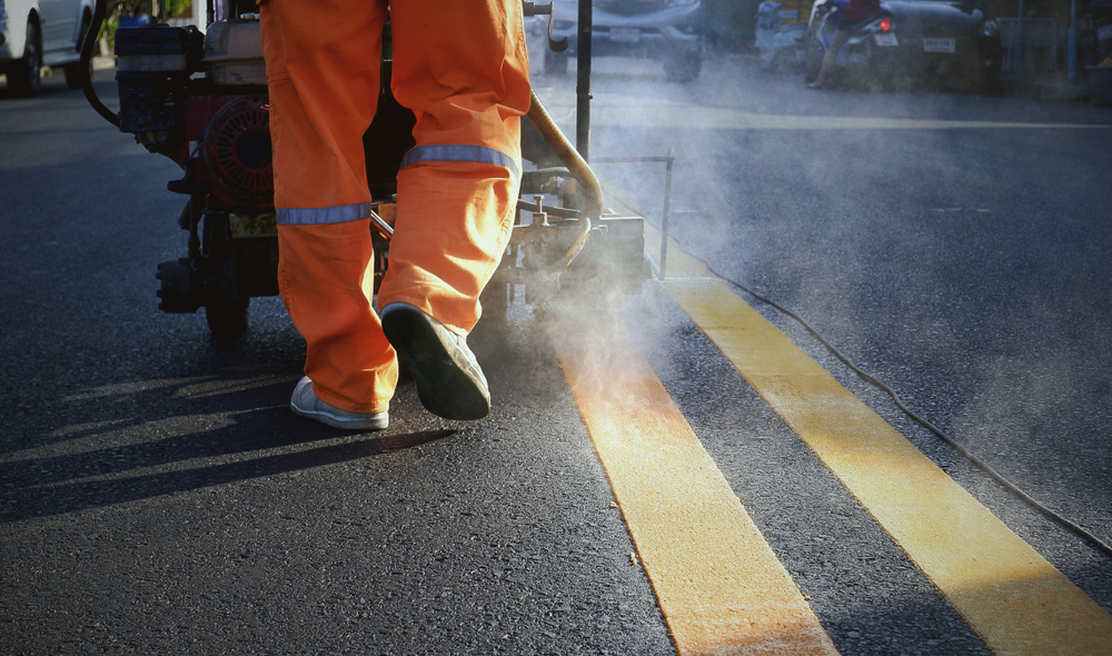 Low,Section,Of,Road,Worker,Using,Thermoplastic,Spray,Marking,Machine