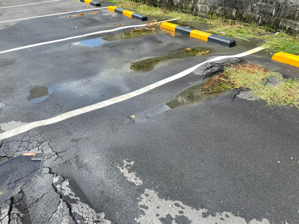 The,Asphalt,Surface,Near,The,Parking,Lot,Is,Potholes,With