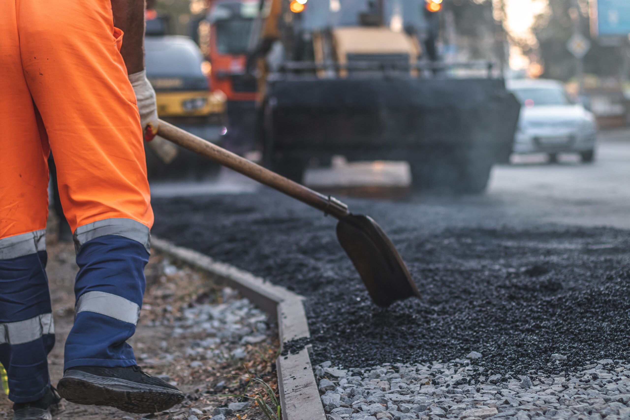 A,Male,Worker,Lays,Asphalt,Pavement,To,Repair,A,Road. repairing Asphalt Project