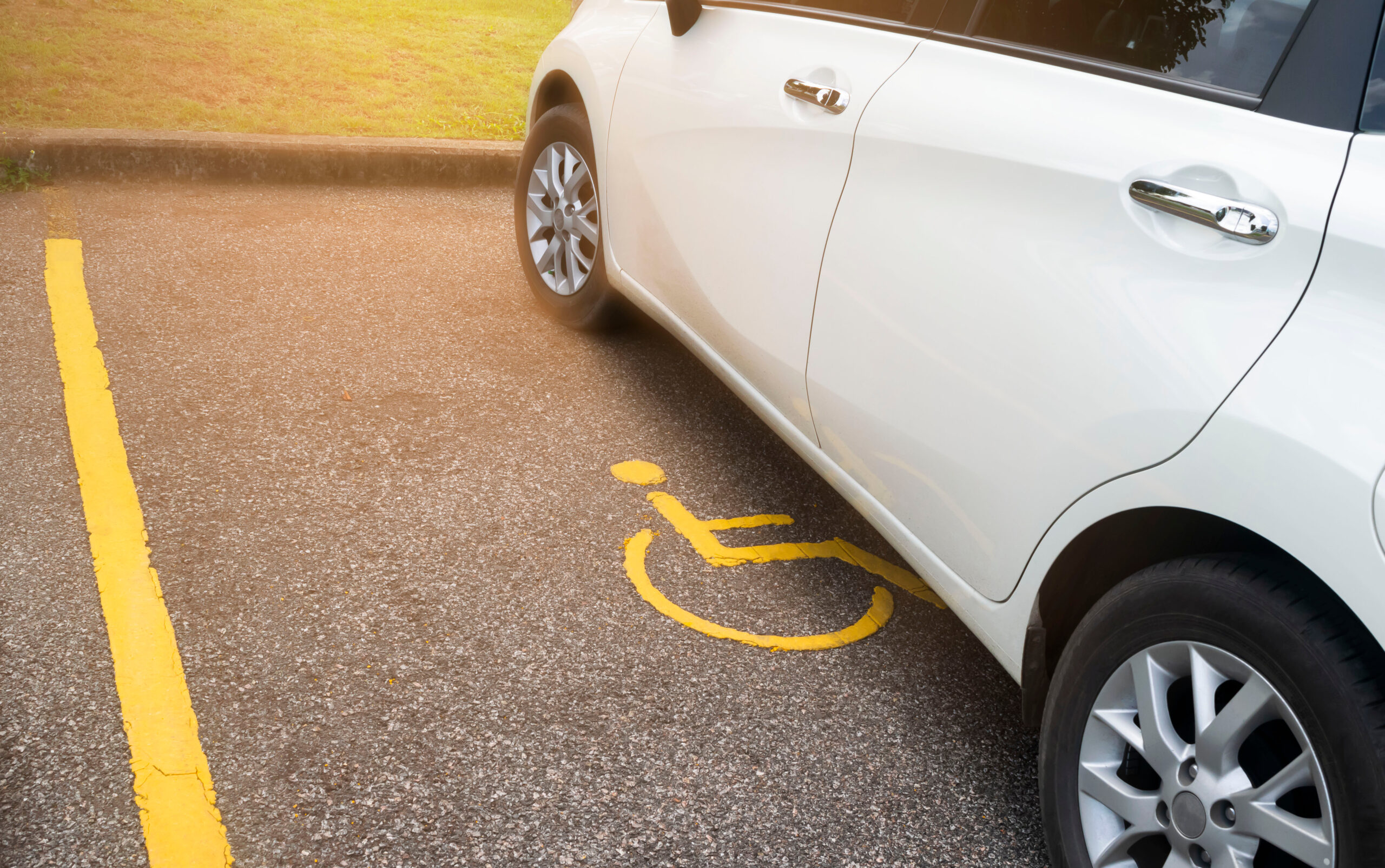 White,Car,Parking,On,Handicapped,Parking,Sign,Area,At,Asphalt