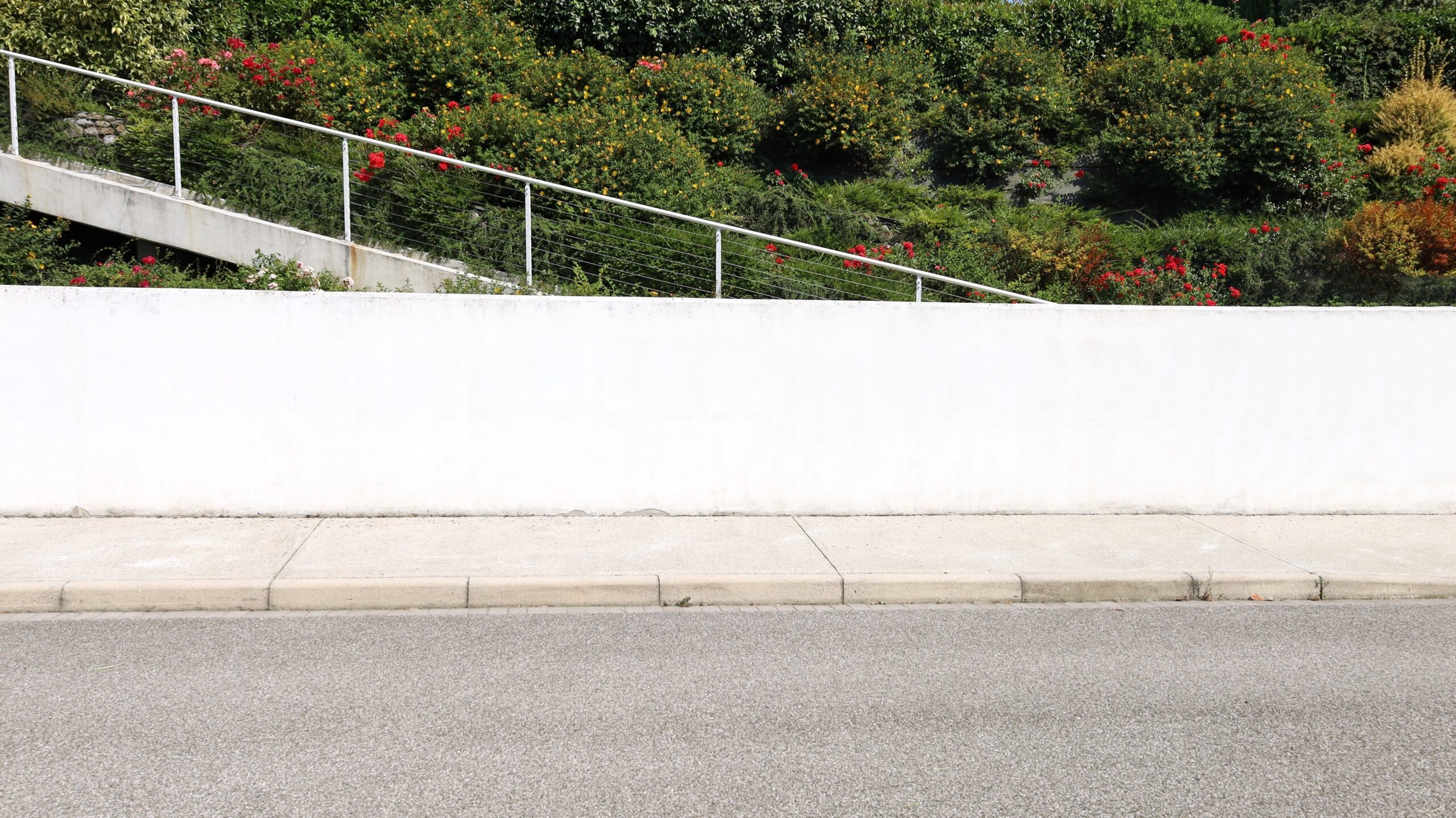 White,Plaster,Fence,With,Flowering,Garden,And,A,Staircase,On